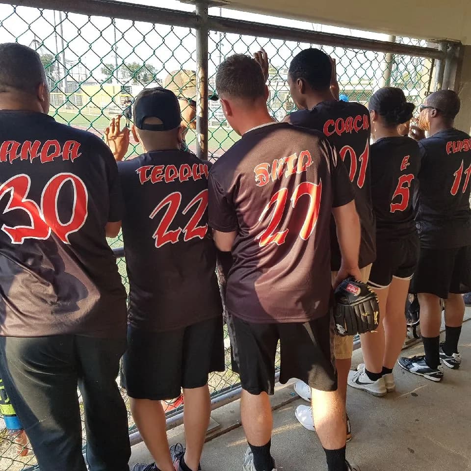 a group of baseball players standing in a dug