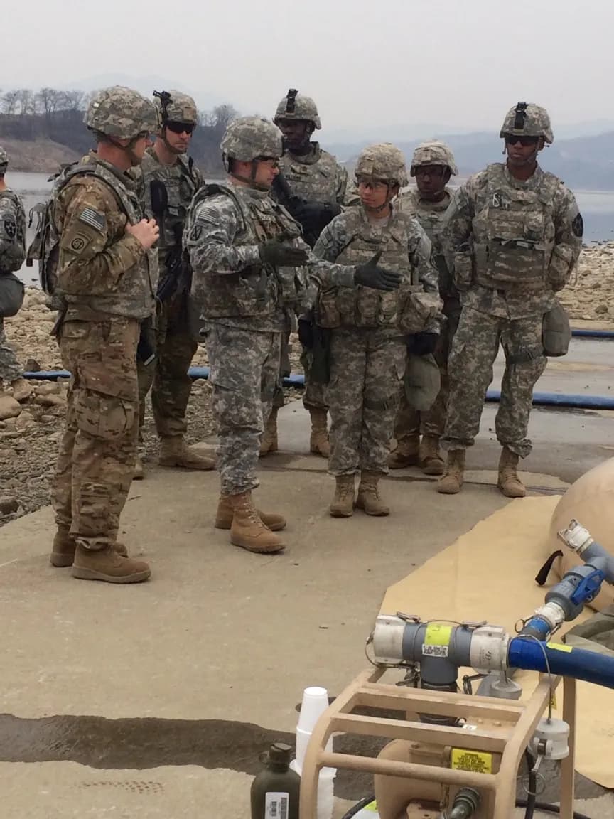 soldiers are gathered around a boat on the water
