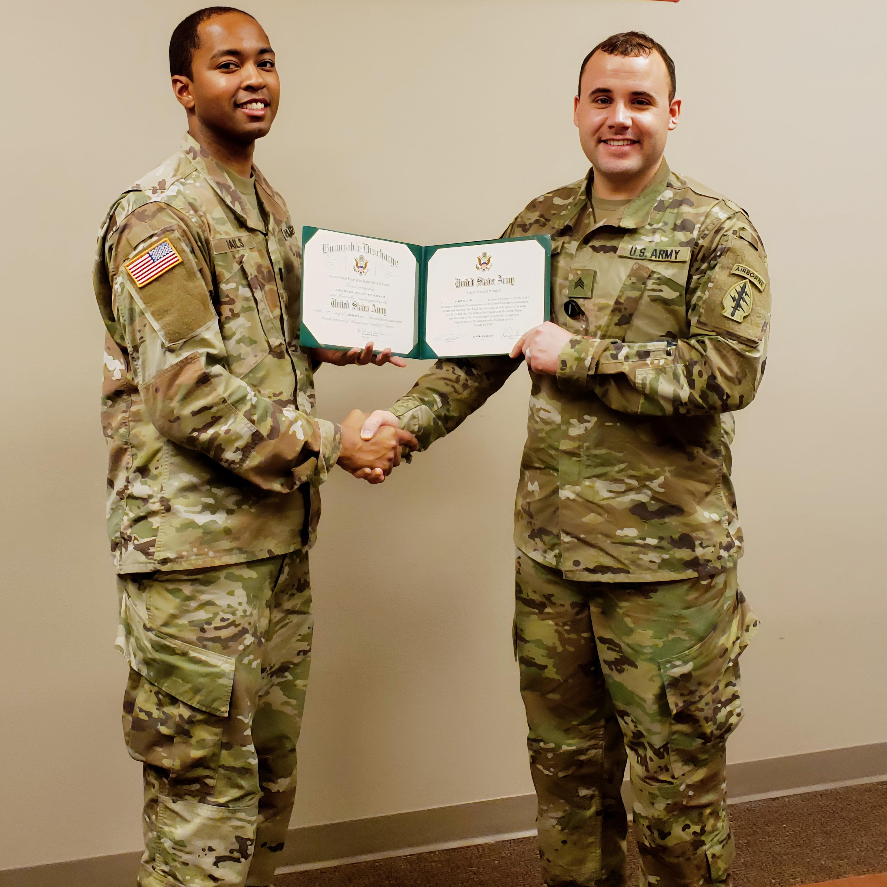 two men in military uniforms holding a certificate