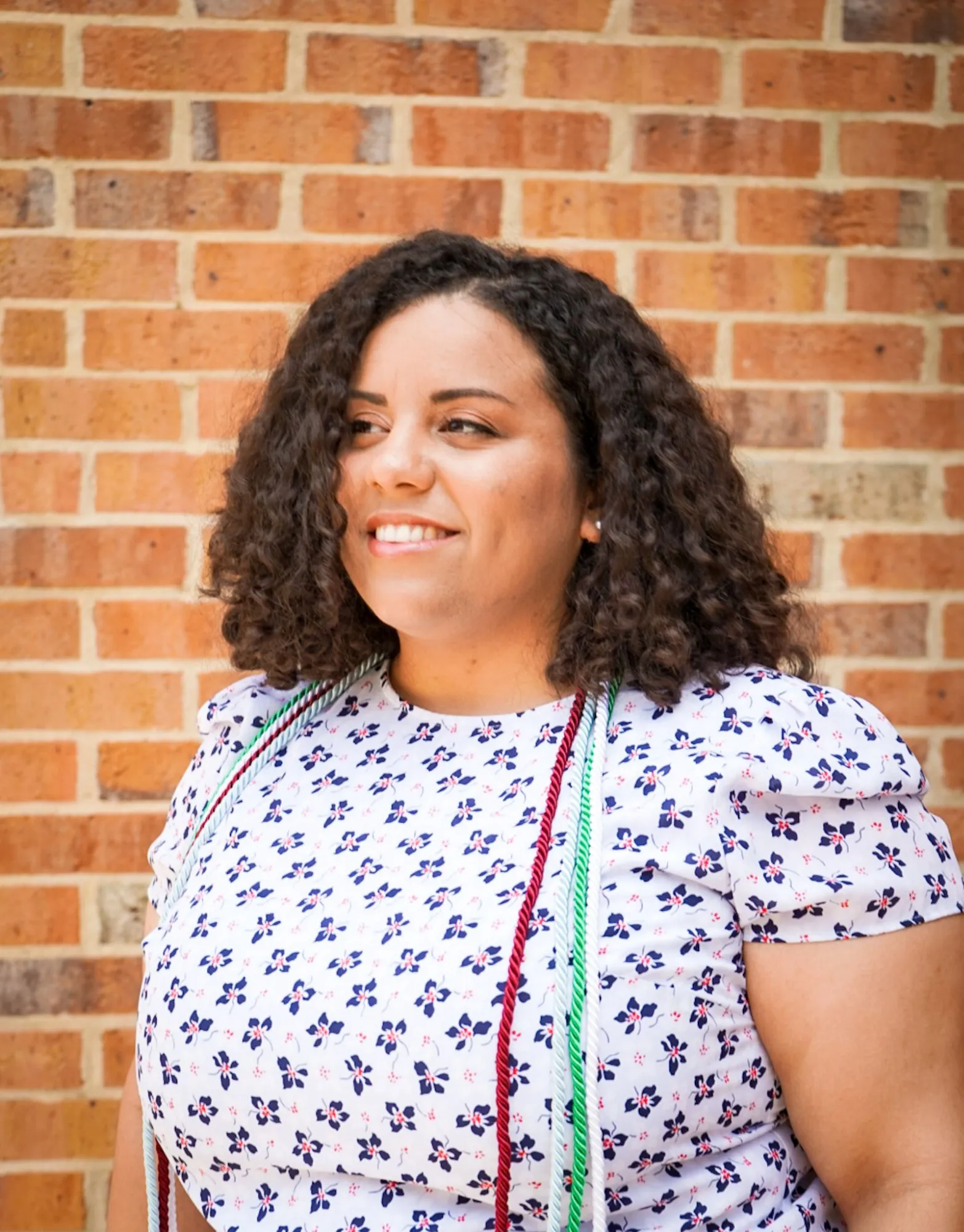 a woman in a white dress standing in front of a brick wall