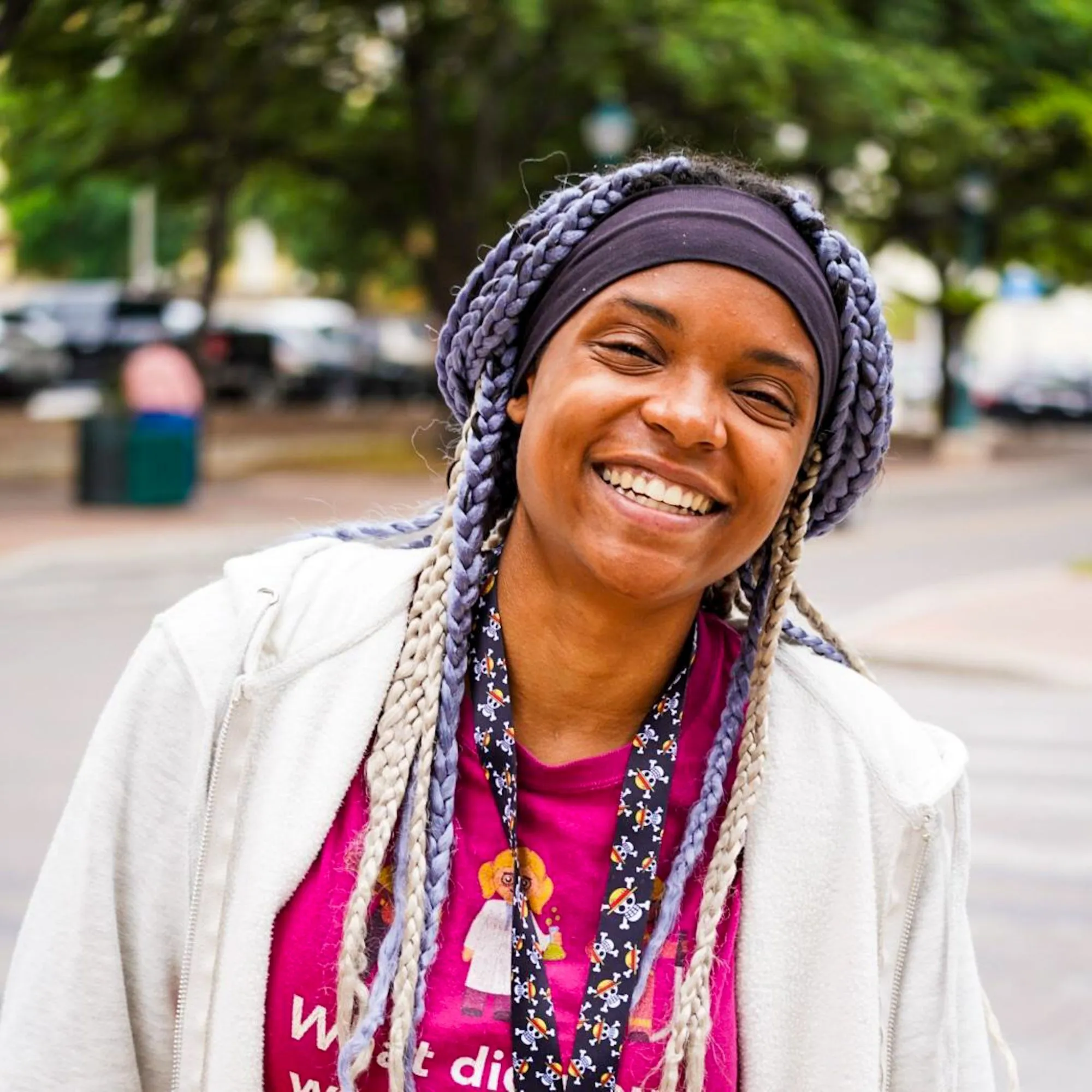 a woman with braids smiles at the camera