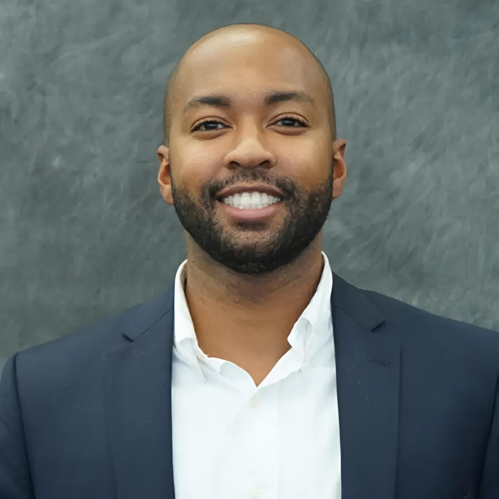 a man in a suit smiling at the camera