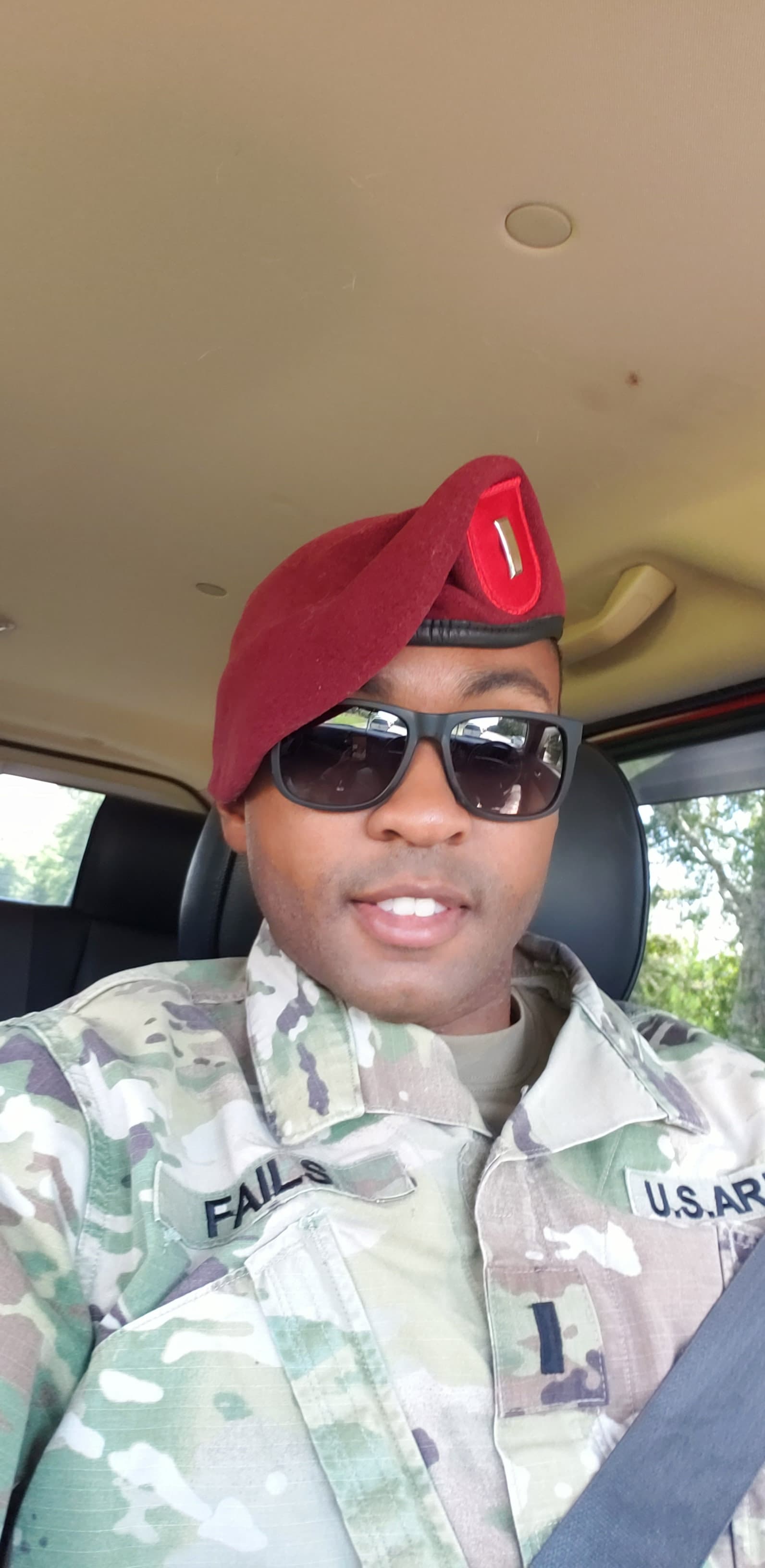 a man in a military uniform is wearing a red hat