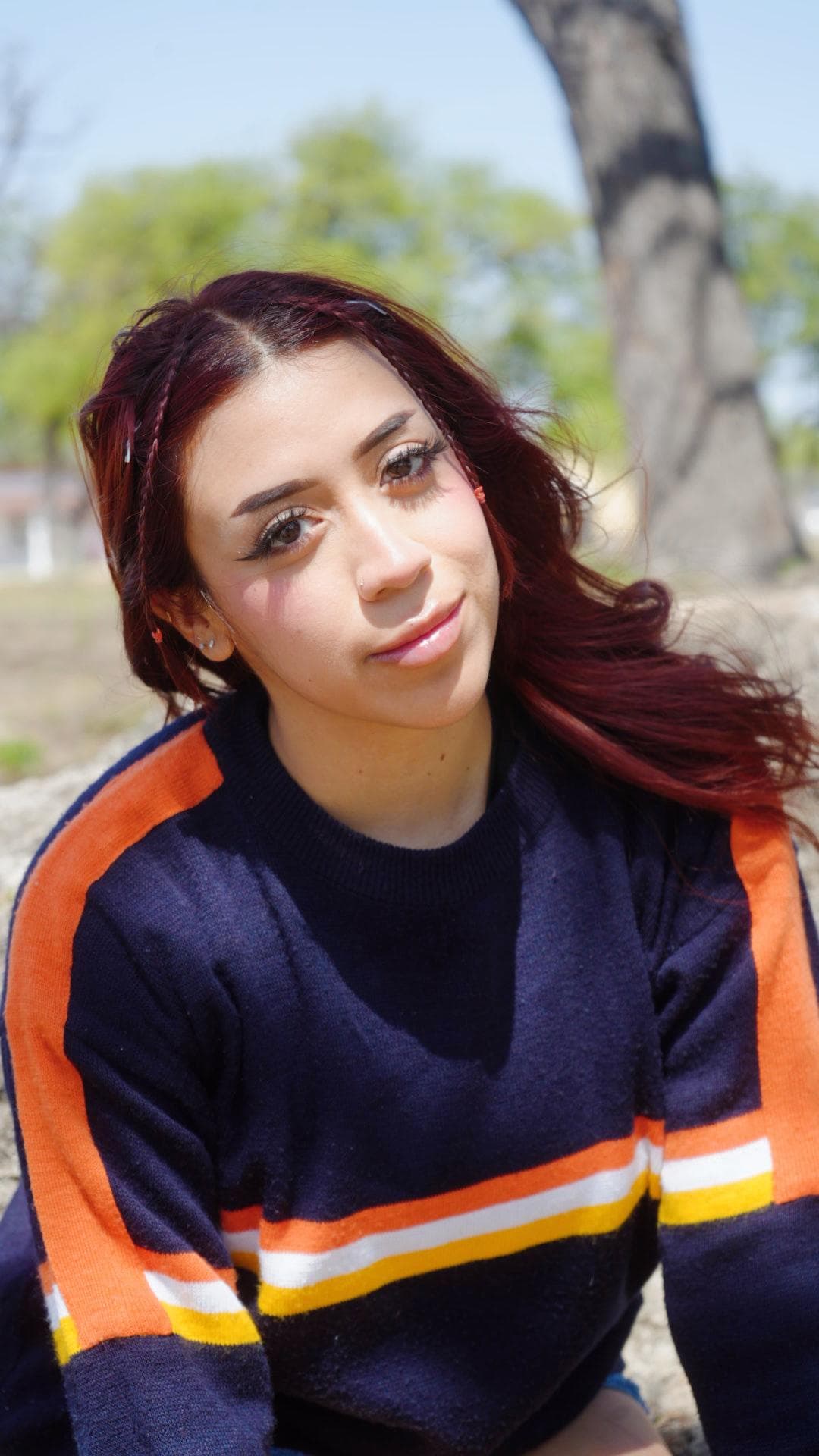 a woman sitting on the ground with her hair in the air