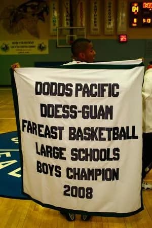 a man holding a sign in a gymnasium