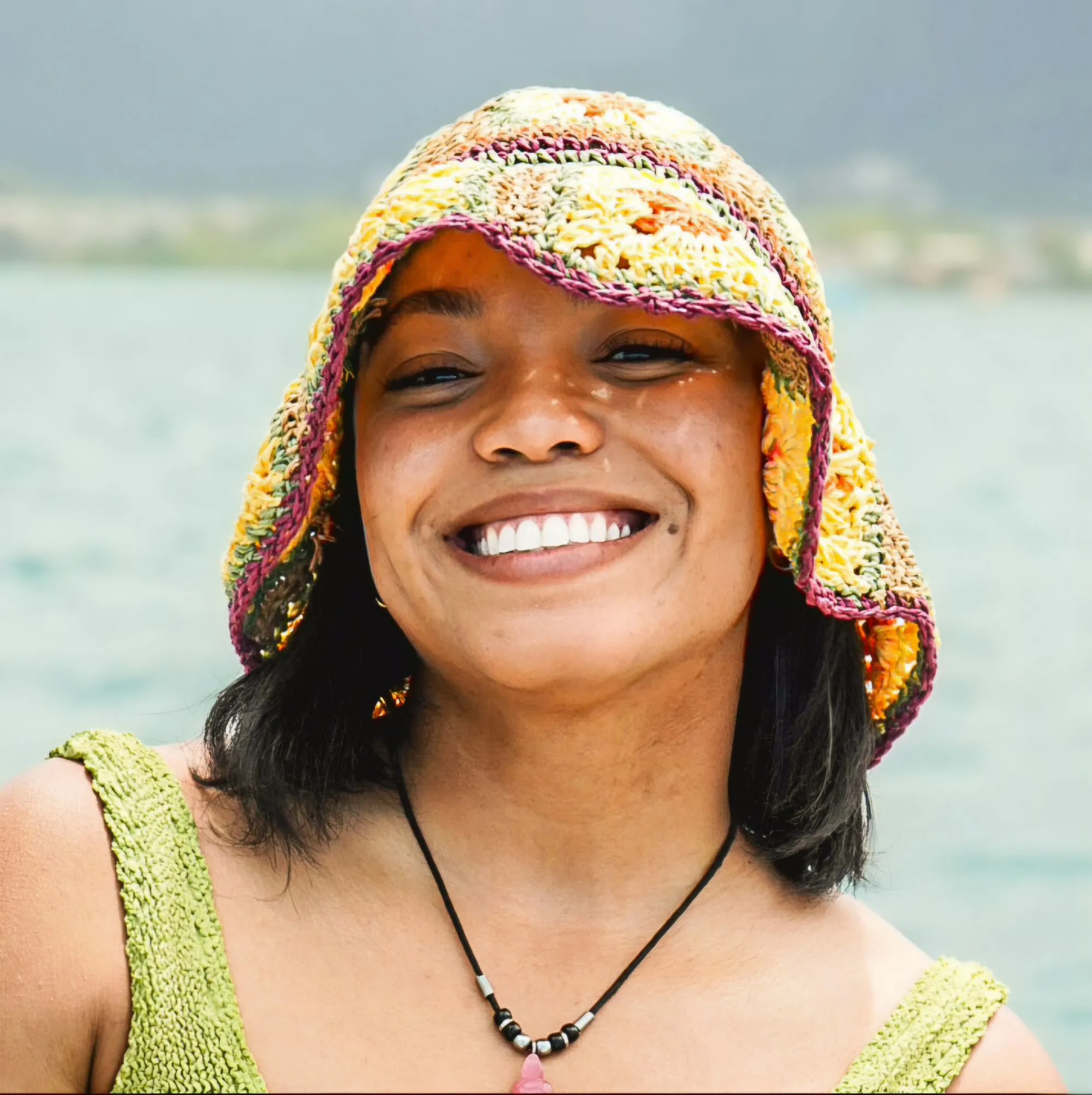 a woman wearing a colorful hat and smiling