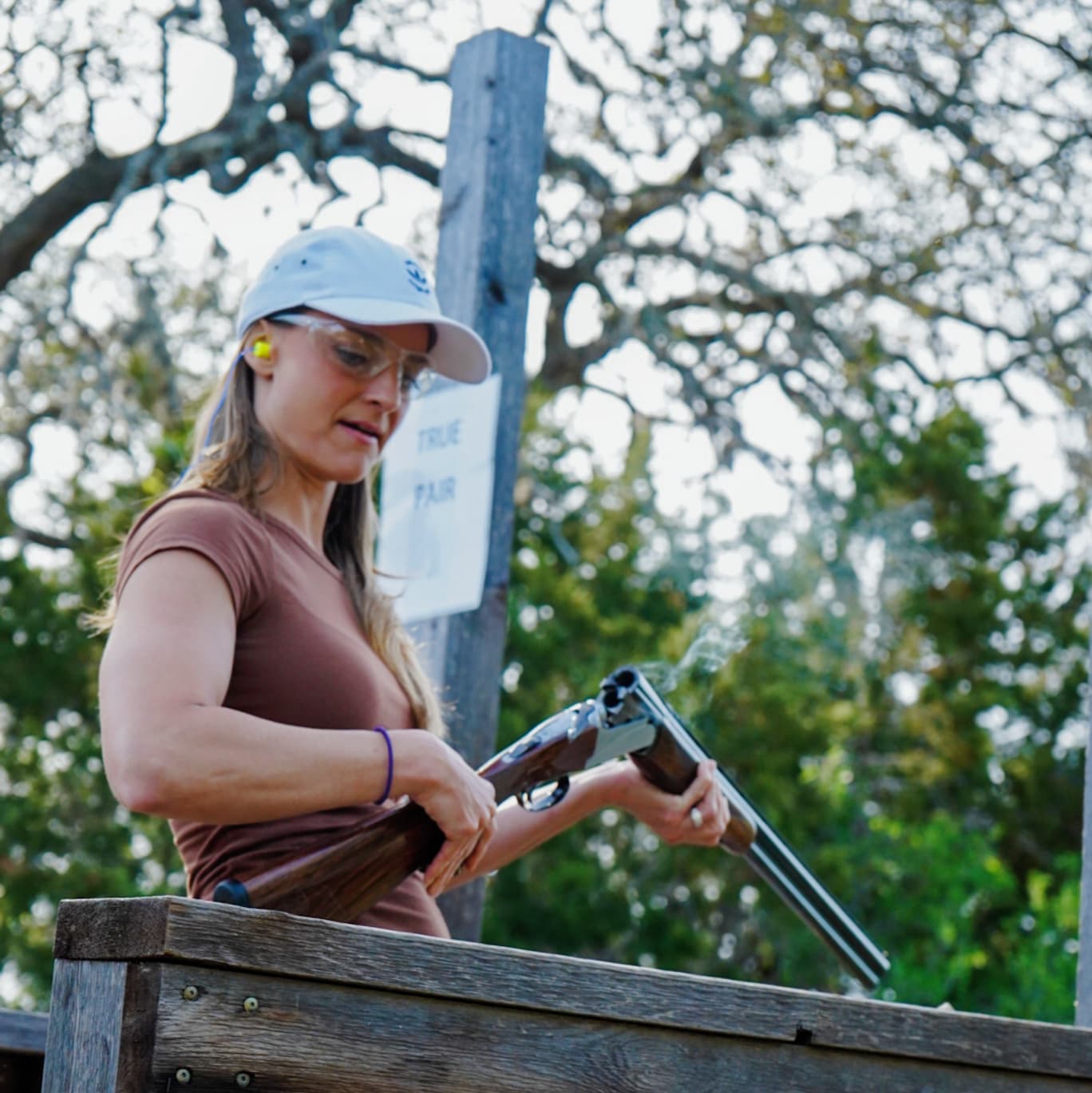a woman in a hat and sunglasses is holding a cell