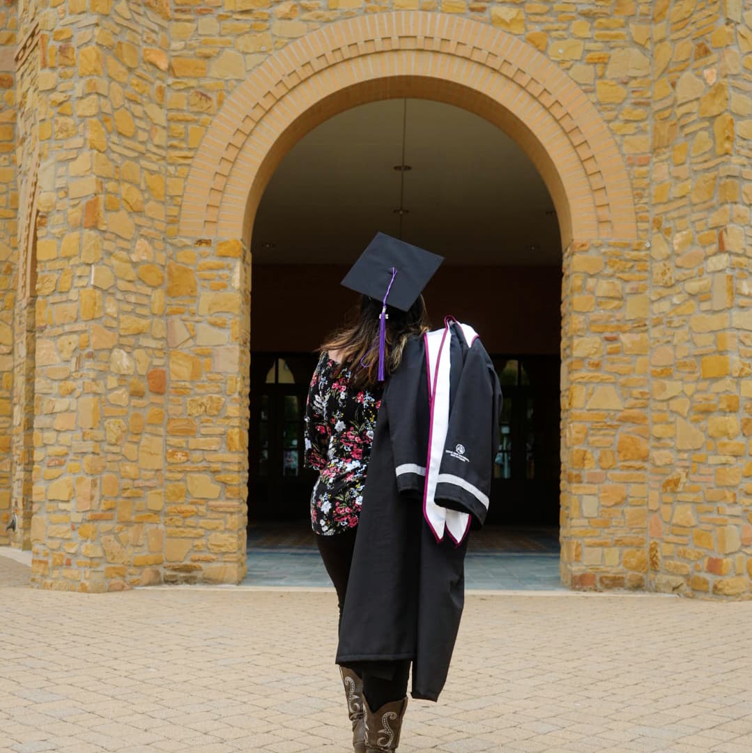 a woman in a graduation gown and hat
